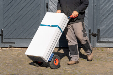 Delivery man pushing hand truck with boxes