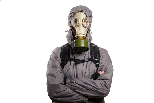 An isolated shot of a man dressed in a gas mask, a hooded jacket, a backpack, crossed his arms on his chest, looking into the camera. On a white isolated background