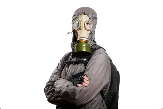 An isolated shot of a man dressed in a gas mask, a hooded jacket, a backpack, crossed his arms on his chest, looking into the camera. On a white isolated background
