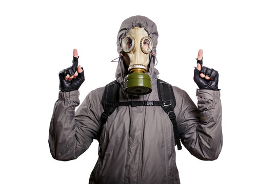 An isolated shot of a man dressed in a gas mask, a jacket with a hood, a backpack, points his index finger up, looks into the camera. On a white isolated background