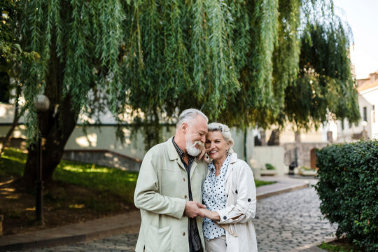 Smiling couple holding hands by tree