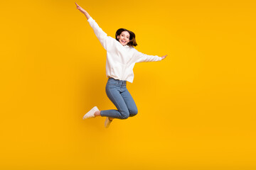 Photo of crazy funky lady jump enjoy free-time wear white hoodie jeans shoes isolated yellow color background