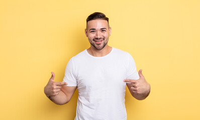 young handsome man looking proud, arrogant, happy, surprised and satisfied, pointing to self,...