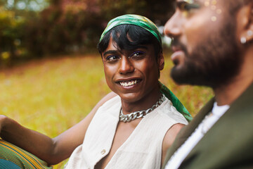 Two Malaysian Indian men surrounded by nature, walking in the grass, laughing together