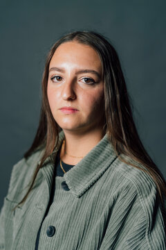 Young Woman With Blank Expression Against Gray Background