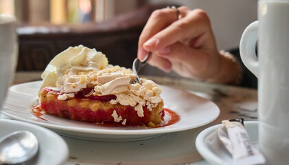 The hand takes a sponge dessert with coffee