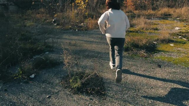 a teenage girl runs away from a pedophile maniac in an escape from the slums, aerial photography.