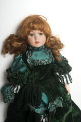 Portrait of vintage dolls wearing a green medieval dress on white background