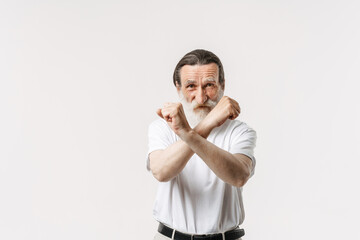 European senior man with beard showing stop gesture at camera