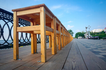 Many wooden chairs stand with each other on the street
