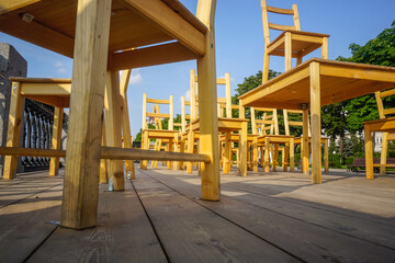 Many wooden chairs stand with each other on the street