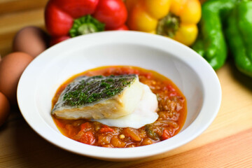 Delicious dish of fresh hake with fresh peppers and vegetables. Typical hemp plate of the cantabrian. Gourmet dish of fresh fish and vegetables.
