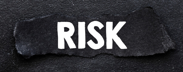 RISK word on black card and black background.