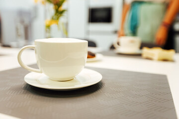 Fototapeta na wymiar three empty white cups are on the kitchen table. pour fragrant morning coffee
