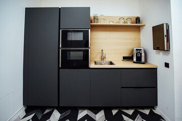 an open refrigerator door in the kitchen in a minimalist design. strict brown kitchen facade. expensive apartment interior