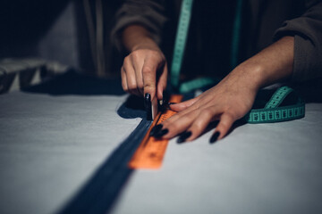 the fashion designer outlines the contours of the pattern on tracing paper. draw with soap and...