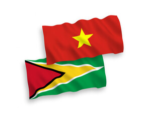 National vector fabric wave flags of Co-operative Republic of Guyana and Vietnam isolated on white background. 1 to 2 proportion.