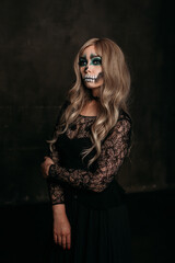 The image of a skeleton girl for Halloween. Female image for Halloween. the woman has long blonde wavy hair, a lace black dress