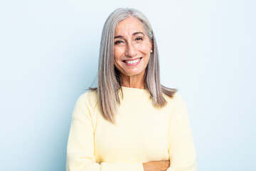middle age gray hair woman looking like a happy, proud and satisfied achiever smiling with arms...