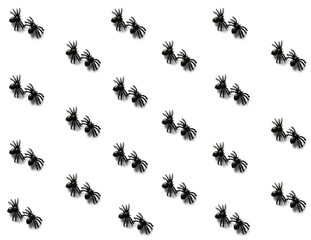 Halloween spooky pattern with the set of two small black plastic spiders on white background. Happy Halloween. Top view.