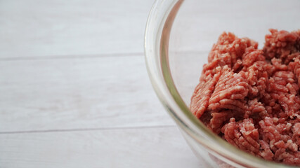 ガラス製のボールに入ったひき肉と左側にコピースペースがある写真