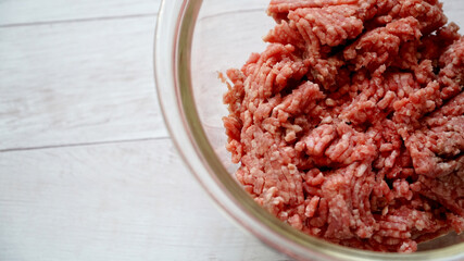 ガラス製のボールに入ったひき肉と左側にコピースペースがある写真