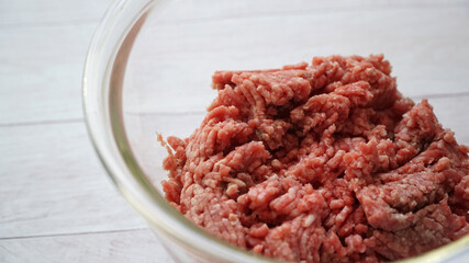 ガラス製のボールに入ったひき肉と左側にコピースペースがある写真