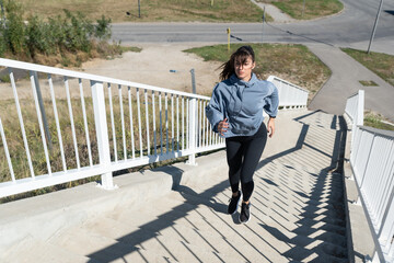 Young active fitness sporty woman run up the stairs in a sports wardrobe doing hardcore cardio workout training for a healthy life and prepares herself as a marathon runner athlete competitor