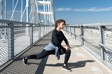 Young sporty fitness runner woman doing warm up exercises and stretching muscles preparation for...