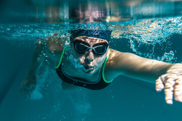 Fototapeta premium Female swimmer in sports outfit at the swimming pool.Underwater photo. 