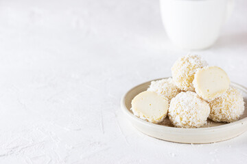 Vegan coconut truffles on a light table. Sugar, lactose and gluten free. Horizontal orientation, copy space.