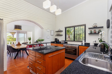 Modern bright kitchen, with a marble table and wooden pedestals. For the preparation and consumption of food, for the residents of the house.