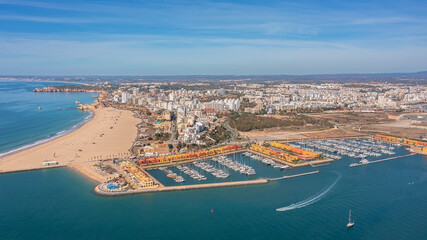 Aerial view of the panorama of the sea bay of Portimao, marinas with luxury yachts. Passing ships with tourists.