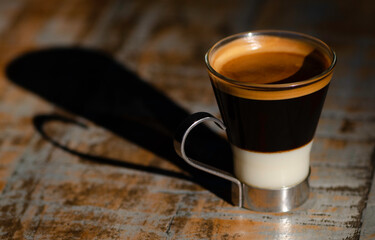 Early morning espresso coffee with condensed milk in a glass cup