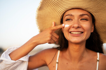 Woman using sunscreen cream. Beautiful girl with sun protection cream..