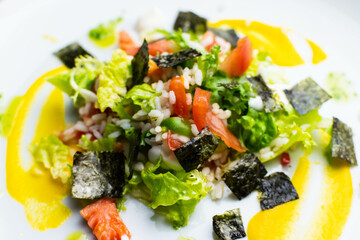 Delicious rice salad with lettuce, tomato, escarole and seaweed. Gourmet salad with natural products.