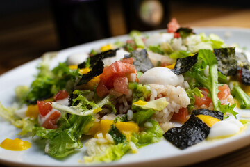 Delicious rice salad with lettuce, tomato, escarole and seaweed. Gourmet salad with natural products.