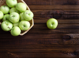 Lots of ripe green apples on a wooden background.