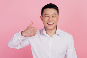 Photo of reliable positive cheerful glad promoter korean man raise thumb up isolated pink color...