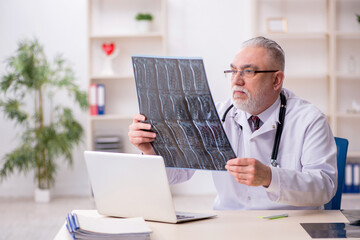 Old male doctor radiologist working in the clinic