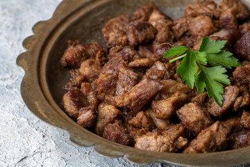 Muslims Traditional Sacrifice holiday food lamb, Turkish roasted meat in copper pot on table top. Turkish Kavurma. (Turkish name; Kurban kavurma)