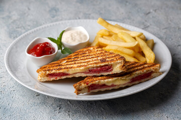 Turkish toast, mixed toast with cheddar cheese, sausage and ham, with fried potatoes (Turkish name; Karisik tost)