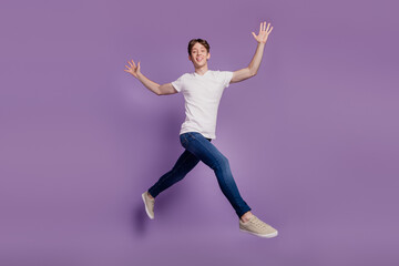 Fototapeta na wymiar Full body profile side photo of young man good mood go walk run jump isolated on violet color background