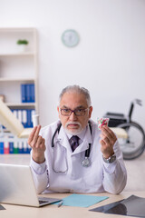 Old male doctor working at the hospital