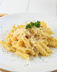 Penne Carbonara Creamy and Rich Italian Pasta Food with Cheese and Parsley on Top. Close Up on White Plate