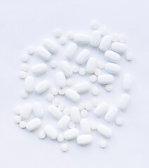 Many white pills on a white background. Health.	
