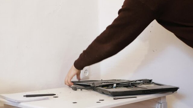 The man smashed laptop with hammer. Error, does not turn on, system crash. person is upset tired stressed, depressed, sad, angry psycho. Broke computer, destroyed, crazy. office worker. screen