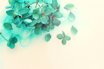 Obraz premium Creative image of emerald and green Hydrangea flowers on artistic ink background. Top view with copy space