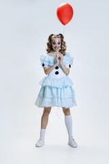 Close-up portrait of charming young girl in Halloween costume of movie character with spooky facial...