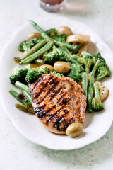 Grilled Turkey Breast with oven baked potatoes and broccoli. Bright  wooden background. Close up. 